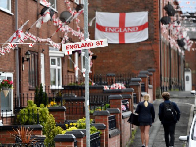 OLDHAM, ENGLAND - JUNE 15: School children walk along Wales Street in Oldham which local residents have re-named England Street and decorated with flags to celebrate the FIFA World Cup Russia 2018 on June 15, 2018 in Oldham, England. England play their first group match against Tunisia on Sunday (Photo …