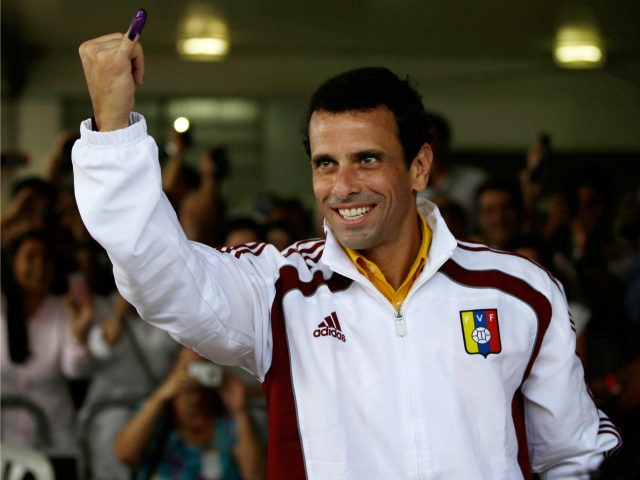 Opposition presidential candidate Henrique Capriles shows his inked finger which was marke