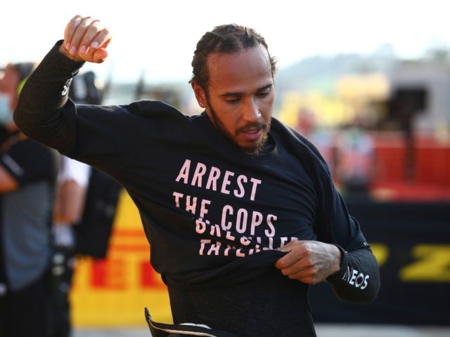 Mercedes driver Lewis Hamilton of Britain puts on a t-shirt after winning the Formula One