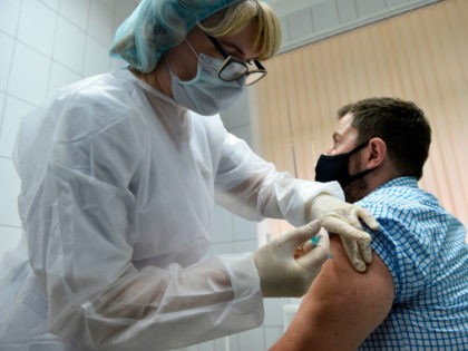 A nurse inoculates volunteer Ilya Dubrovin, 36, with Russia's new coronavirus vaccine in a