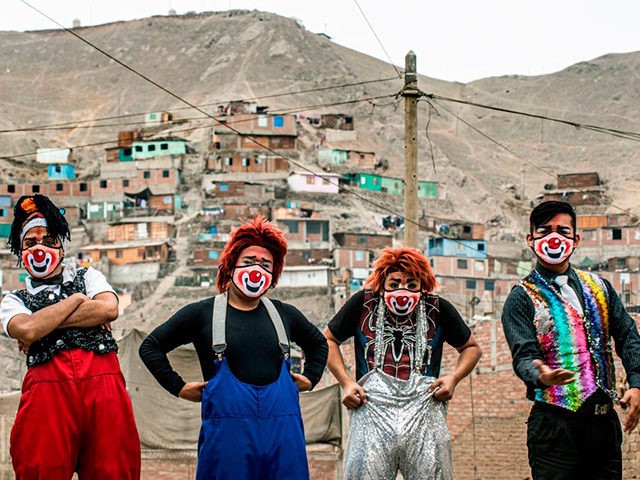 Clowns wearing face masks pose for a picture before performing at Puente Piedra district, in the northern outskirts of Lima on August 03, 2020, during the COVID-19 pandemic. - Due to the coronavirus pandemic, circuses in Peru remain closed, leading this group of clowns traveling in their mototaxi circus to …