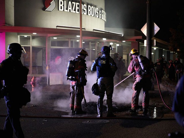 Firemen extinguish a fire set by protestors in front of the North Precinct Police building in Portland, Oregon on September 6, 2020. - Protestors are marching for an end to racial inequality and police violence. Aaron Danielson, 39, a supporter of a far-right group called Patriot Prayer, was fatally shot …