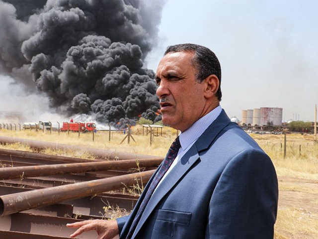 Kirkuk Governor Rakan Said al-Juburi looks on as he stands away from a plume of smoke bill
