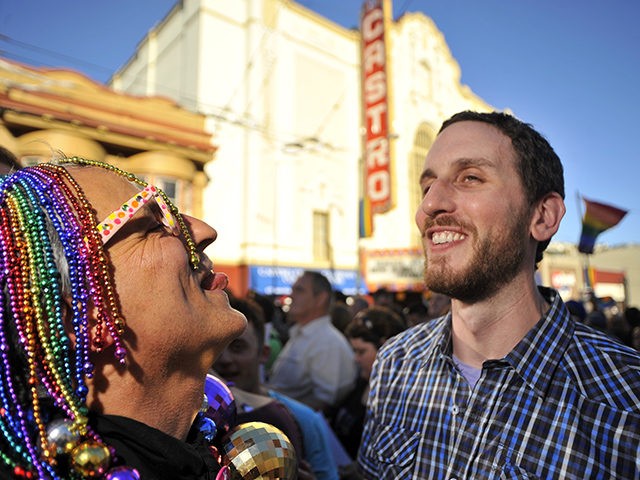 San Francisco District 8 Supervisor Scott Weiner (R) looks on as celebrations ensue in the