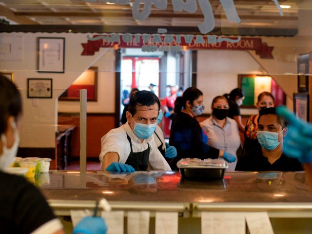A server at The Original Ninfa's wears gloves and a mask while bringing takeout orders to the kitchen amid the novel coronavirus pandemic on May 1, 2020 in Houston, Texas. - Texas on Friday became the largest US state to begin easing coronavirus lockdown measures despite reporting a single-day high …