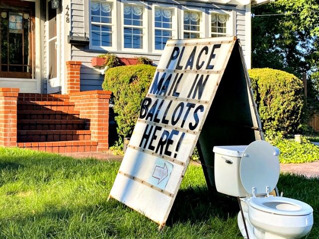 A political display is set up in the lawn of a home on West Columbia Street in Mason, Mich