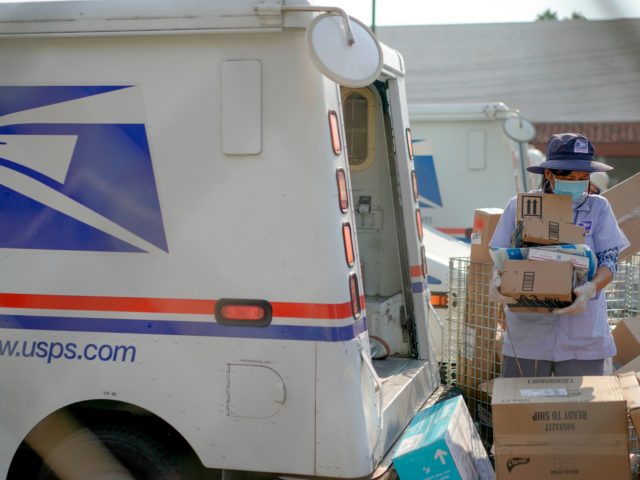 Postal workers sort, load and deliver mails as protesters hold a "Save the Post Office" demonstration outside a United States Postal Service location in Los Angeles, California, on August 22, 2020. - Postmaster General Louis DeJoy on August 21 denied claims he was working to undermine mail delivery, after comments …