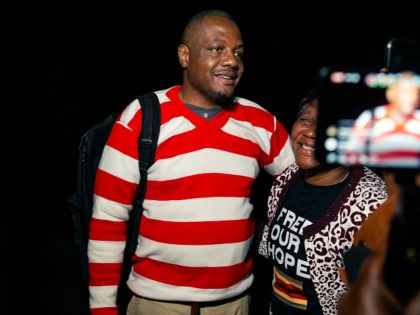 Zimbabwean journalist Hopewell Chin'ono is embraced by a supporter following speaking to the press after his release on bail from Chikurubi Maximum Prison in Harare, on September 2, 2020. - Opposition politician Jacob Ngarivhume and award-winning journalist Hopewell Chin'ono were granted bail on September 2, 2020 at their fourth attempt …