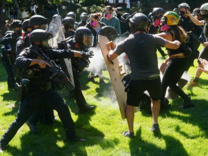 Federal officers disperse a crowd of anti-police protesters after the group chased right wing groups out of downtown and then continued protesting in Terry Schrunk Plaza on August 22, 2020 in Portland, Oregon. For the second Saturday in a row, right wing groups gathered in downtown Portland, sparking counter protests …