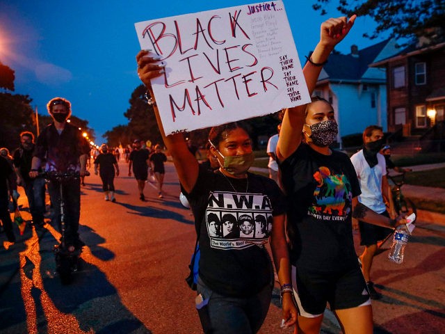 A protester holds a Black Lives Matter sign during a demonstration against the shooting of Jacob Blake in Kenosha, Wisconsin on August 26, 2020. - Outrage continued to spread after Kenosha, Wisconsin police shot Jacob Blake multiple times in the back point-blank in front of his children in the Midwestern …