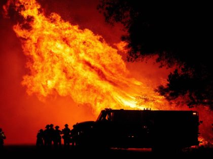 TOPSHOT - Butte county firefighters watch as flames tower over their truck during the Bear fire in Oroville, California on September 9, 2020. - Dangerous dry winds whipped up California's record-breaking wildfires and ignited new blazes, as hundreds were evacuated by helicopter and tens of thousands were plunged into darkness …
