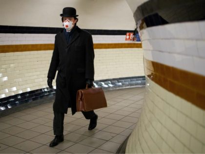 A commuter wears a face mask as a precautionary measure against the novel coronavirus COVID-19 as he walks at Lambeth North station to a Bakerloo line train on the London Underground on April 2, 2020. - Prime Minister Boris Johnson said Britain would "massively increase testing" amid a growing wave …