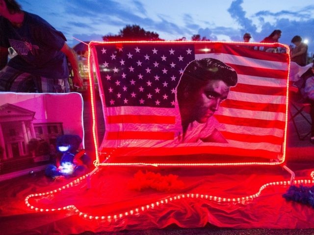 A street memorial is lit during a candlelight vigil for Elvis Presley in front of Graceland, Presley's Memphis home, on Tuesday, Aug. 15, 2017, in Memphis, Tenn. Fans from around the world are at Graceland for the 40th anniversary of his death. Presley died Aug. 16, 1977. (AP Photo/Brandon Dill)