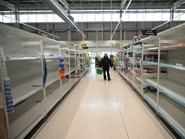 A shopper walks past empty toilet roll shelves amidst the novel coronavirus COVID-19 pandemic, in Manchester, northern England on March 20, 2020. - The British prime minister urged people in his daily press conference on March 19 to be reasonable in their shopping as supermarkets emptied out of crucial items -- notably toilet roll -- across Britain. The government said it was temporarily relaxing elements of competition law to allow supermarkets to work together to maintain supplies. (Photo by Oli SCARFF / AFP) (Photo by OLI SCARFF/AFP via Getty Images)