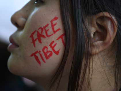 TOPSHOT - An exiled Tibetan activist face is painted with the slogan "Free Tibet" during a