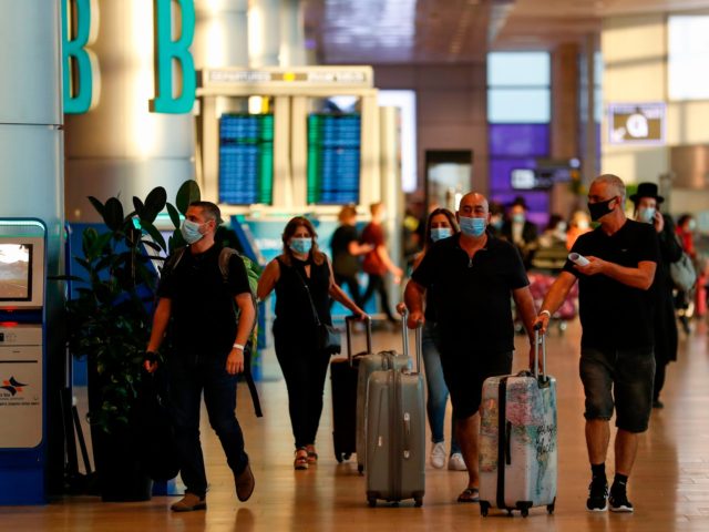 Passengers, wearing protective facemasks, are pictured at Israel's Ben Gurion Airport in L