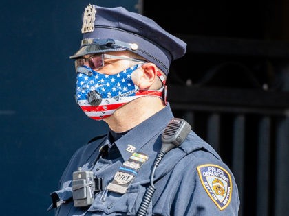 Side angle of an NYPD Officer wearing a patriotic American Flag themed N95 Ventilator Mask while on duty in New York City