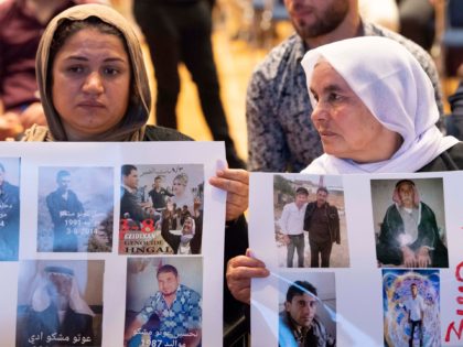Yazidi women hold up pictures of missed relatives during a commemoration ceremony in Stuttgart, southern Germany, on August 3, 2019. - The Central Yazidi Council in Germany commemorates the 5th anniversary of the genocide of the Yazidi in August 2014 when fighters of the Islamic State (IS) killed thousands of …