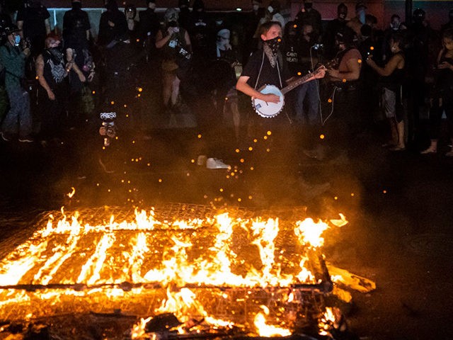 PORTLAND OR - SEPTEMBER 6: Protesters chant in front of a fire near the North police precinct during a protest against racial injustice and police brutality on September 6, 2020 in Portland, Oregon. Sunday marked the 101st consecutive night of protests in Portland. (Photo by Nathan Howard/Getty Images)