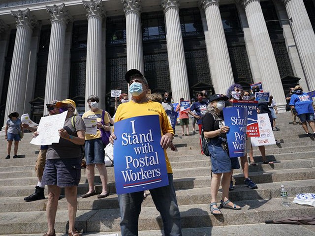Protestors hold a signs during the "Save The Postal Service Day of Action " at the James A