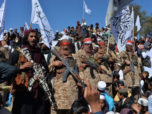TOPSHOT - Afghan Taliban militants and villagers attend a gathering as they celebrate the