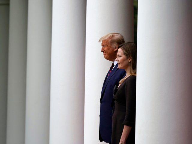 President Donald Trump walks with Judge Amy Coney Barrett to a news conference to announce