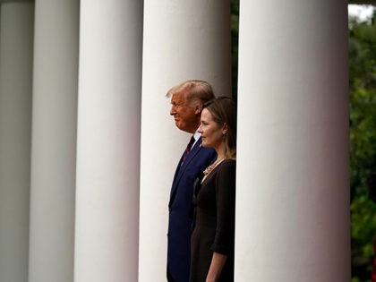 President Donald Trump walks with Judge Amy Coney Barrett to a news conference to announce