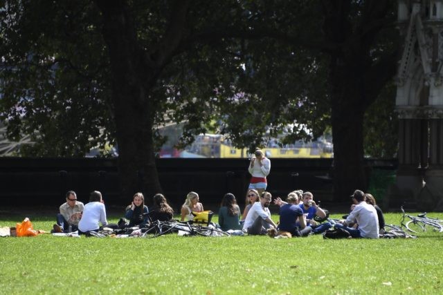 People sit on the grass at Victoria Gardens, in London, Thursday, Sept. 10, 2020. From Monday, social gatherings of more than six people will be banned in England — both indoors and outdoors — and Boris Johnson hinted that such restrictions will potentially remain in place until or through Christmas. …