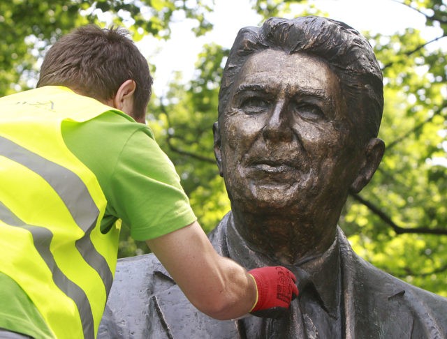 Cleaner Adam Gawronski polishes the bronze monument of former U.S. President Ronald Reagan in downtown Warsaw, Poland, on Friday, June 3, 2016, ahead of the NATO summit to be held in Warsaw in July, to be attended by President Barack Obama, and ahead of the June 5 anniversary of Reagan's …