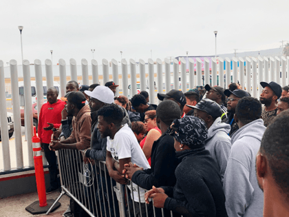 In this Sunday, July 28, 2019, photo, migrants in Tijuana, many from Cameroon, listen to n