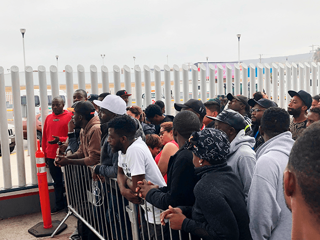 In this Sunday, July 28, 2019, photo, migrants in Tijuana, many from Cameroon, listen to names being called for those who can claim asylum that day in the US. English-speaking Cameroonians fleeing atrocities of their French-speaking government helped push Tijuana’s asylum wait list to 10,000 on Sunday, up from 4,800 …