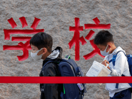 Students wearing face masks to help curb the spread of the coronavirus walk in line as they arrive at a primary school in Beijing, Monday, Sept. 7, 2020. Students in the capital city returned to school on Monday in a staggered start to the new school year because of the …
