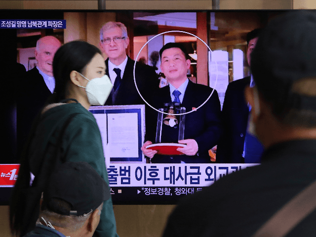 People watch a TV showing an image of Jo Song Gil, the North Korea's former ambassador to