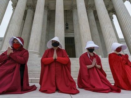 Activists opposed to the confirmation of President Donald Trump's Supreme Court nominee, Judge Amy Coney Barrett, are dressed as characters from "The Handmaid's Tale," at the Supreme Court on Capitol Hill in Washington, Sunday, Oct. 11, 2020. Barrett's confirmation hearing begins Monday before the Republican-led Senate Judiciary Committee. (AP Photo/J. …