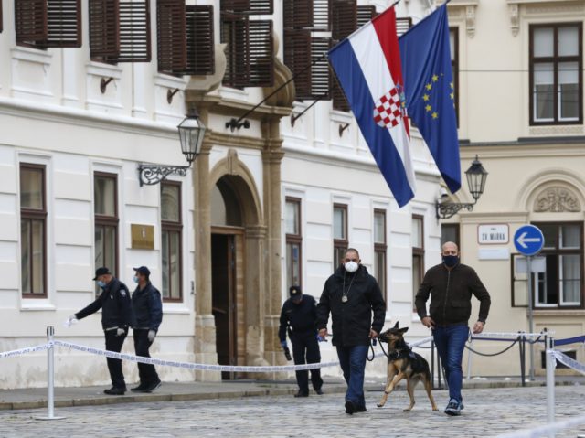 Police officers inspect the site of shooting in Zagreb, Croatia, Monday Oct. 12, 2020. A g