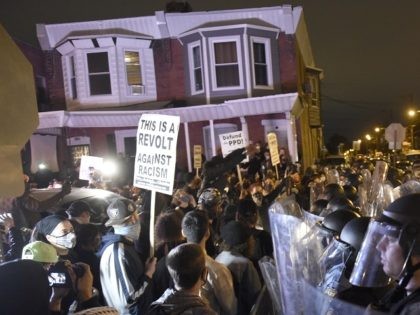 La policía vigila a manifestantes en Filadelfia el 27 de octubre del 2020, luego de que la muerte de un individuo de raza negra a manos de la policía generase protestas. (AP Photo/Michael Pérez)