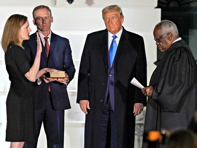 President Donald Trump watches as Supreme Court Justice Clarence Thomas administers the Constitutional Oath to Amy Coney Barrett on the South Lawn of the White House White House in Washington, Monday, Oct. 26, 2020, after Barrett was confirmed to be a Supreme Court justice by the Senate earlier in the …