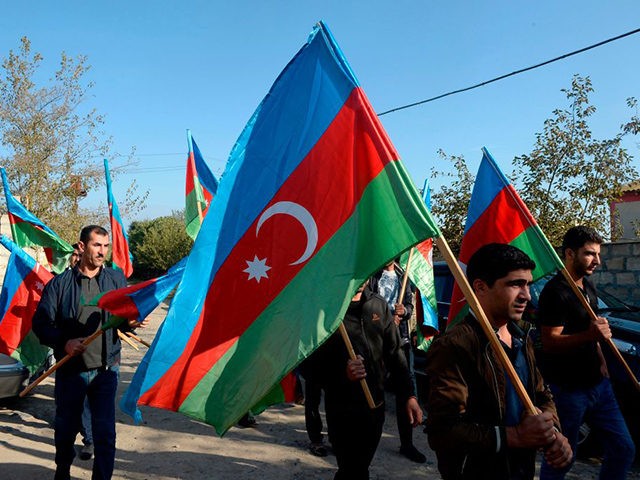 TOPSHOT - Men walk with Azerbaijani flags during a funeral ceremony of an Azeri serviceman