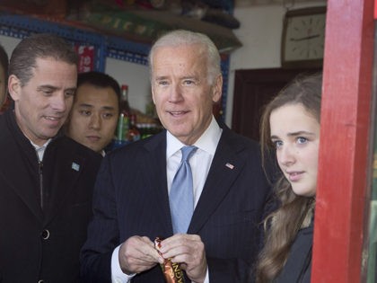 US Vice President Joe Biden (C) buys an ice-cream at a shop as he tours a Hutong alley with his granddaughter Finnegan Biden (R) and son Hunter Biden (L) in Beijing on December 5, 2013. Biden said on December 5 China's air zone had caused "significant apprehension" and Beijing needed …