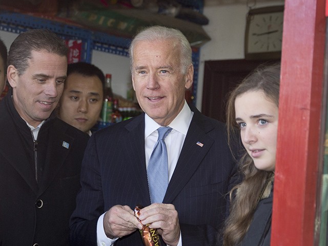 US Vice President Joe Biden (C) buys an ice-cream at a shop as he tours a Hutong alley with his granddaughter Finnegan Biden (R) and son Hunter Biden (L) in Beijing on December 5, 2013. Biden said on December 5 China's air zone had caused "significant apprehension" and Beijing needed to reduce Asia-Pacific tensions to protect its growing stake in regional peace and stability. AFP PHOTO / POOL / Andy Wong (Photo credit should read ANDY WONG/AFP via Getty Images)