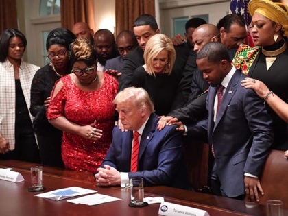 TOPSHOT - US President Donald Trump (C) stands in a prayer circle with African-American le