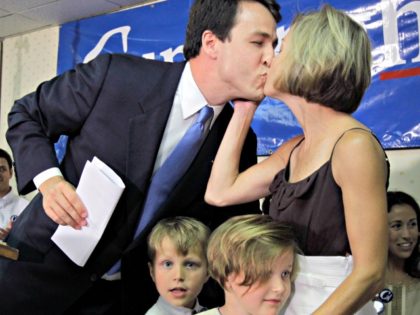 Democratic U.S. Senate candidate Cal Cunningham, left, gets a kiss from his wife, Elizabeth, right, as their children Carolina, bottom right, and Will, bottom left, look on at his campaign rally headquarters in Lexington, N.C., Tuesday, June 22, 2010 after losing in a runoff election to Elaine Marshall. (AP Photo/Chuck …