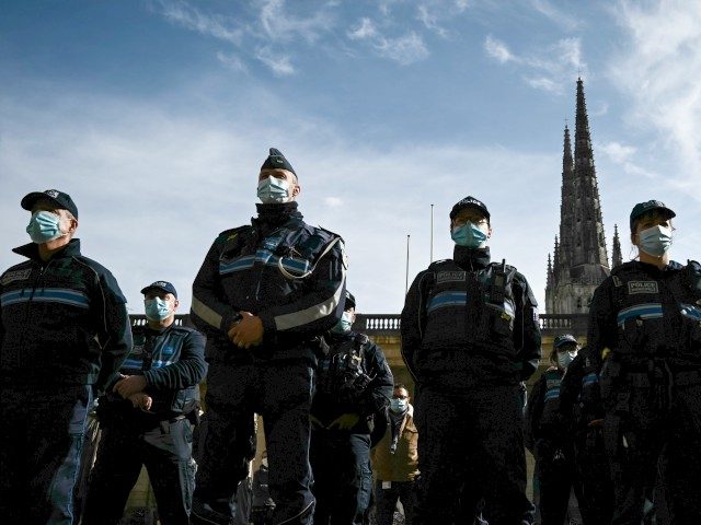 TOPSHOT - Policemen observe a minute of silence in the courtyard of the Bordeaux city hall on October 19, 2020, in homage to history teacher Samuel Paty who was beheaded by an attacker who was shot dead by policemen. (Photo by Philippe LOPEZ / AFP) (Photo by PHILIPPE LOPEZ/AFP via …