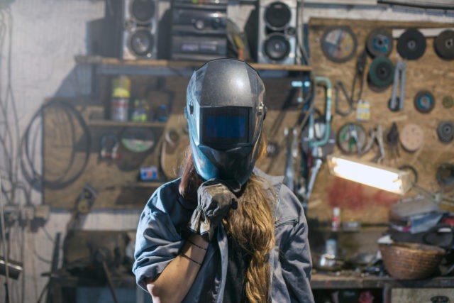 woman with welding mask in workshop