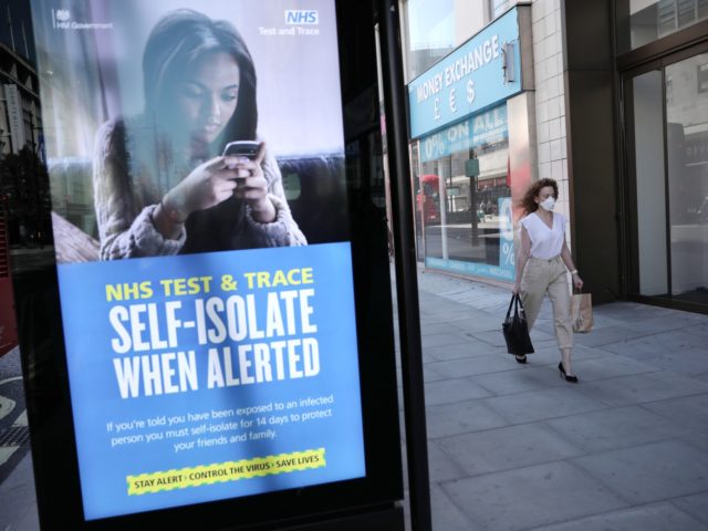 LONDON, ENGLAND - JUNE 15: A woman walks past an NHS Test and Trace advertisement on Oxford Street as stores reopen following closure due to the coronavirus outbreak on June 15, 2020 in London, United Kingdom. The British government have relaxed coronavirus lockdown laws significantly from Monday June 15, allowing …