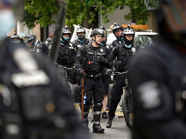 Seattle Police prepare to move in on demonstrators blocking the intersection of East Pine Street and 11th Avenue after the Capitol Hill Occupied Protest (CHOP) was cleared out and police retook the department's East Precinct in Seattle, Washington on July 1, 2020. (Photo by Jason Redmond / AFP) (Photo by …