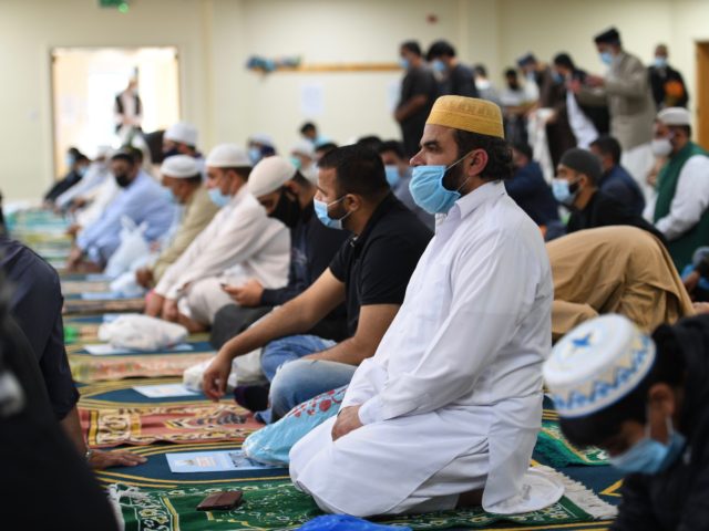 Worshippers sit on their personal prayer mats, socially distanced and wearing facemasks during Friday prayers at Madina Masjid, Sheffield's central mosque, in Sheffield, northern England, on July 24, 2020. - The Sheffield central mosque has taken a number of safety measures including temperature checks, taking details for contact tracing purposes, …