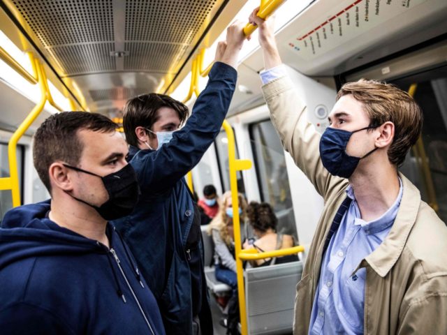 People wear mask on a metro train in Copenhagen shortly after midnight, on August 22, 2020, as the Danish government imposed to wear face mask or visor in public transport to prevent the spread of the new coronavirus. (Photo by Olafur STEINAR GESTSSON / Ritzau Scanpix / AFP) / Denmark …
