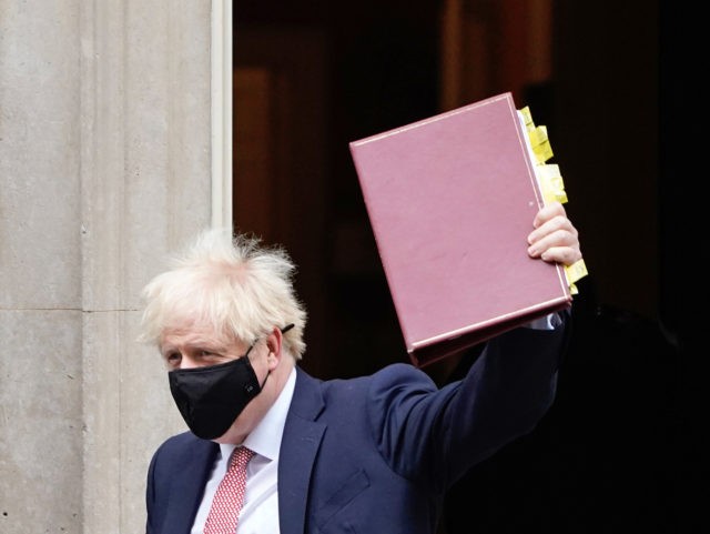 Britain's Prime Minister Boris Johnson, wearing a face covering due to the COVID-19 p