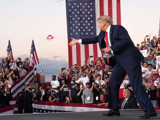 US President Donald Trump throws masks to supporters as he arrives to hold a Make America Great Again rally as he campaigns at Orlando Sanford International Airport in Sanford, Florida, October 12, 2020. (Photo by SAUL LOEB / AFP) (Photo by SAUL LOEB/AFP via Getty Images)